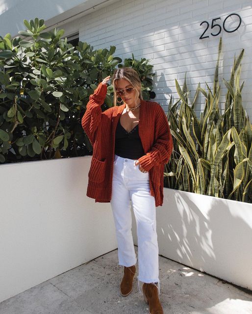 Cô gái mặc áo sơ mi cam đất và quần trắng, tạo phong cách thanh lịch.